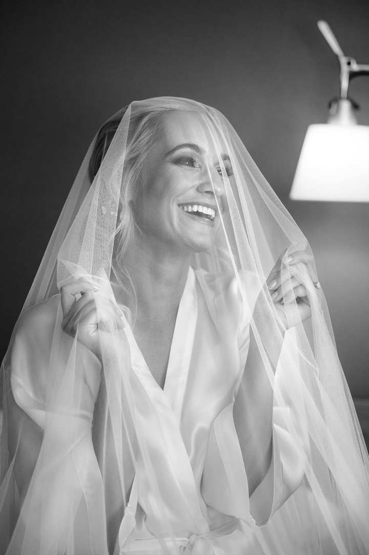 Bride in a veil, softly smiling, capturing a moment of serenity at the Obelisk Winery wedding.