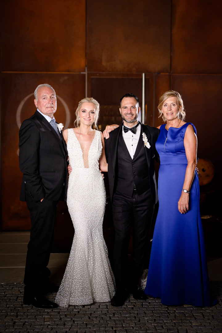 Bride and groom with family members posing at Obelisk Winery wedding.