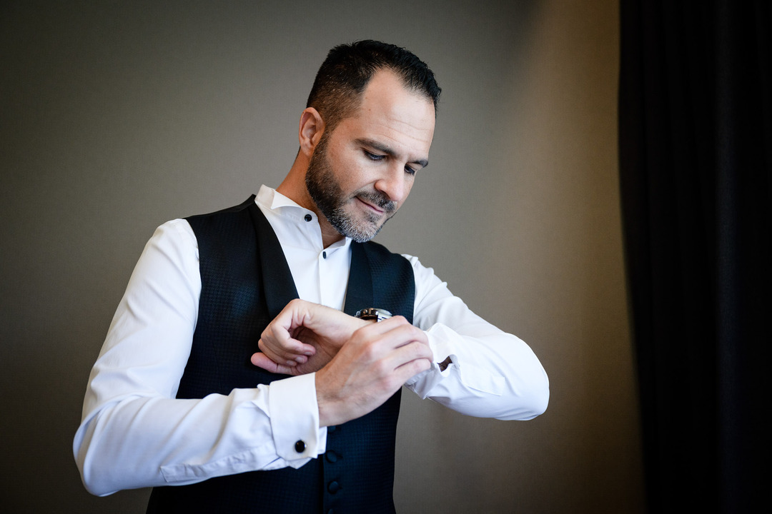 Groom adjusting his cufflinks, preparing for the wedding ceremony at Obelisk Winery.