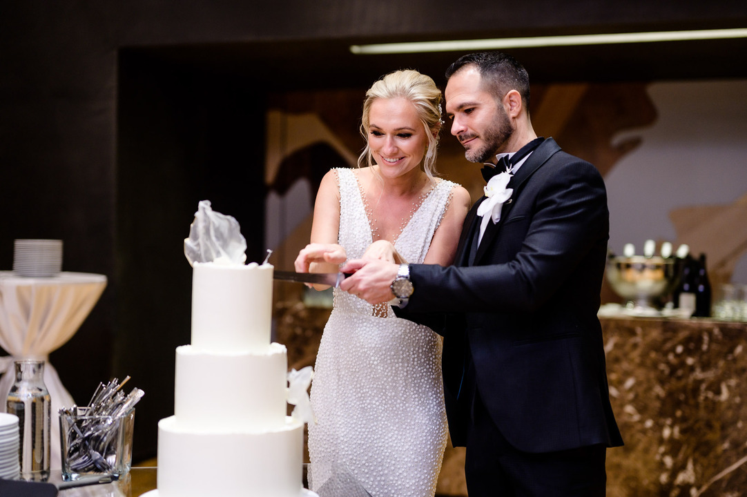  A bride and groom cutting a wedding cake at Obelisk Winery, surrounded by elegant decor.