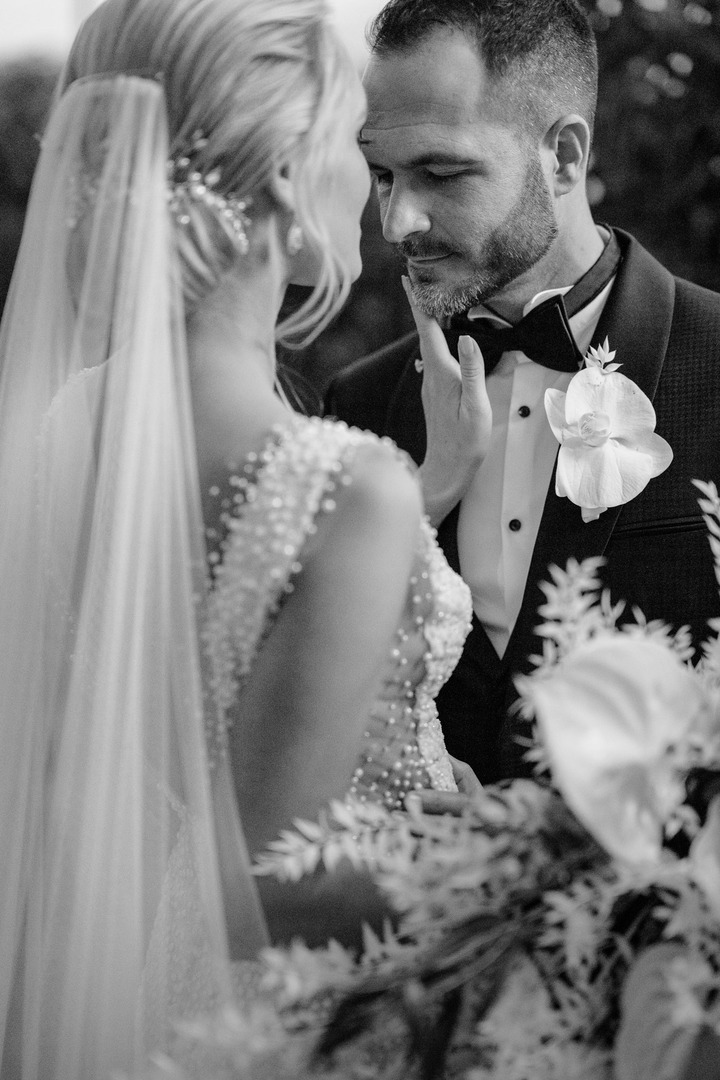 Black and white photo of the bride gently touching the groom's face.