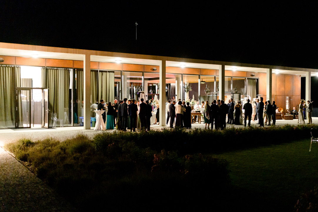 View of the outdoor area of the Obelisk Winery, with guests standing and chatting. A cimbalom band is playing in the background.