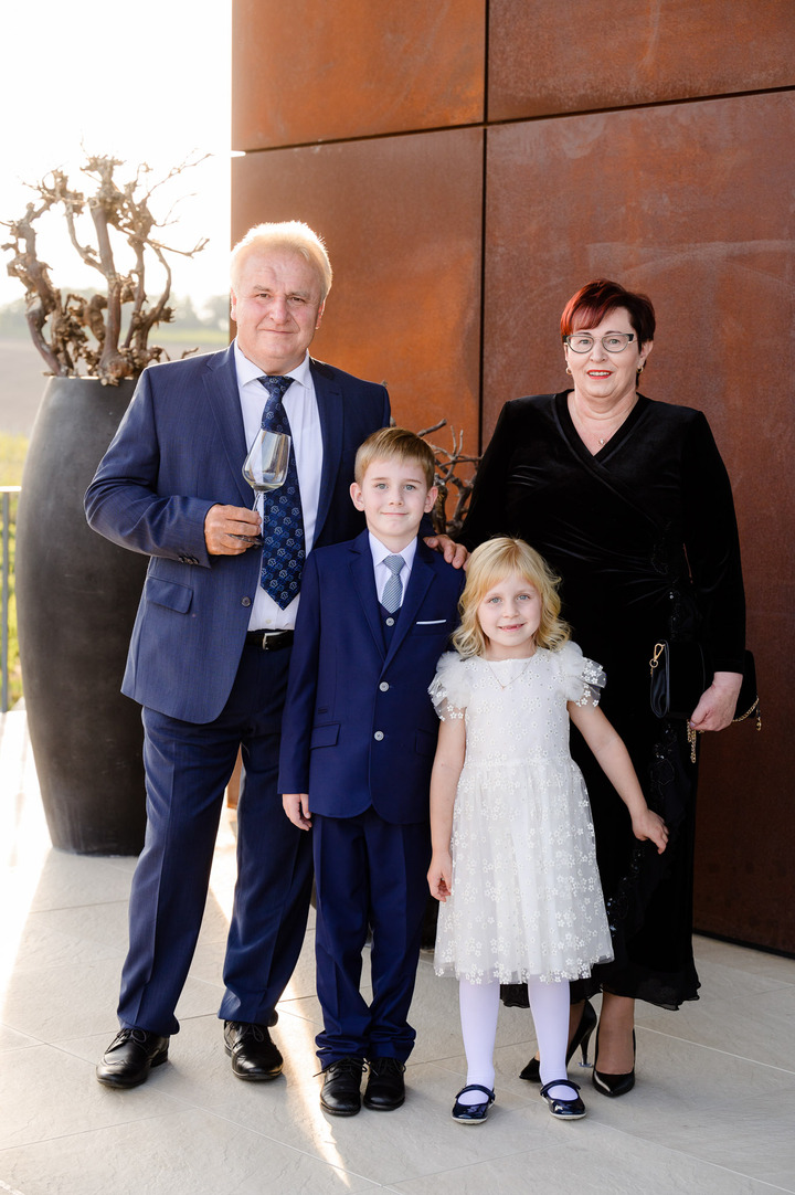 A family with two children poses in front of the Obelisk Winery.