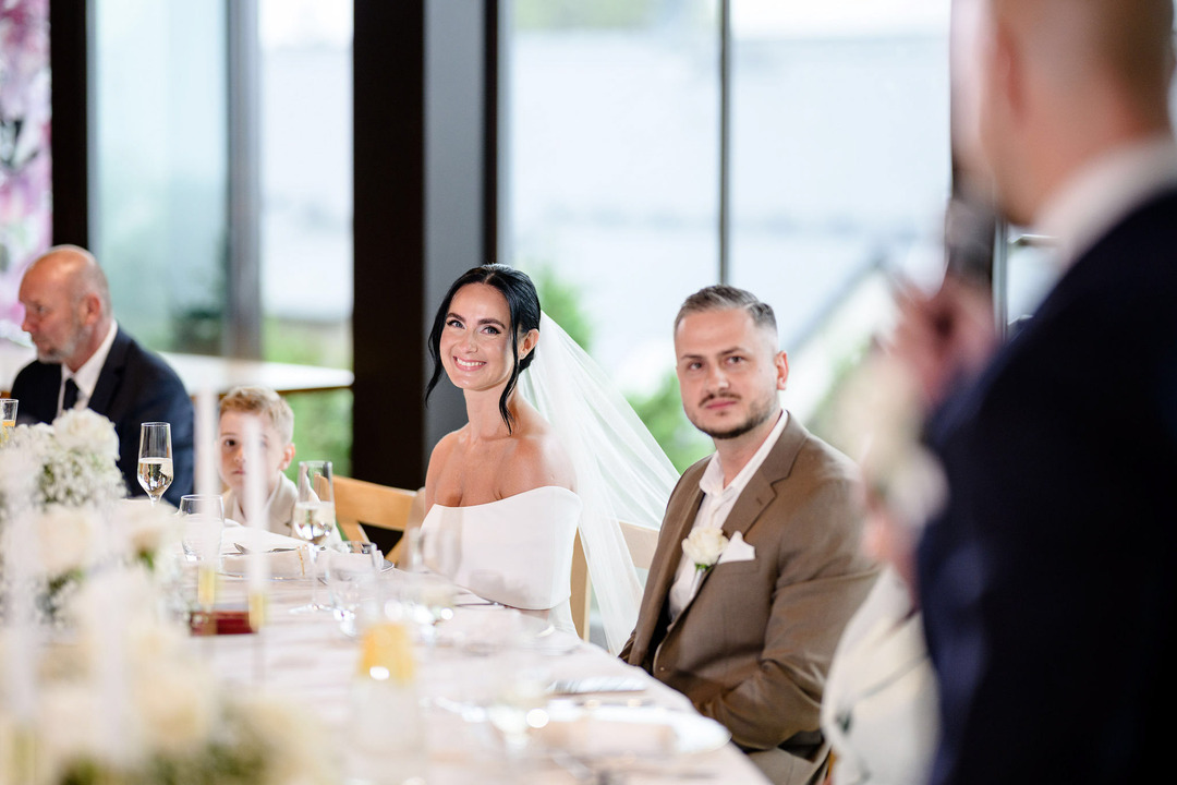 Newlyweds listening to the best man’s speech with tears in their eyes.
