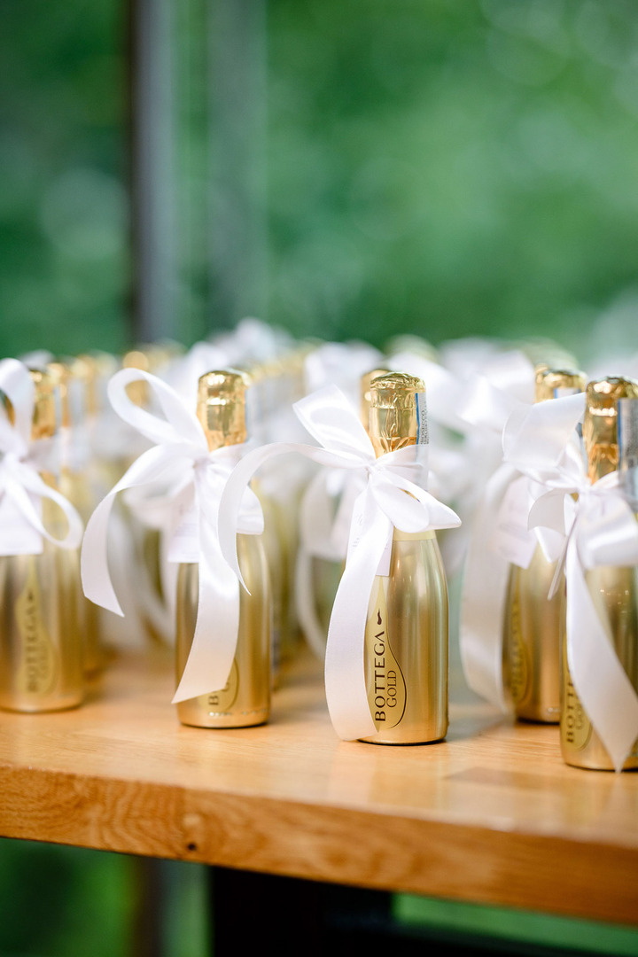 Guest favors – small bottles of golden champagne with a white ribbon.
Guest favors – small bottles of golden champagne with a white ribbon.
