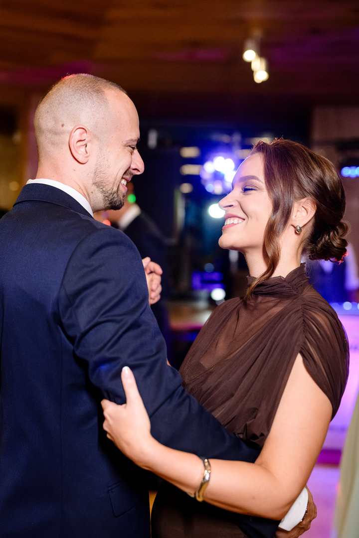 A married couple among the guests dancing joyfully on the dance floor.
