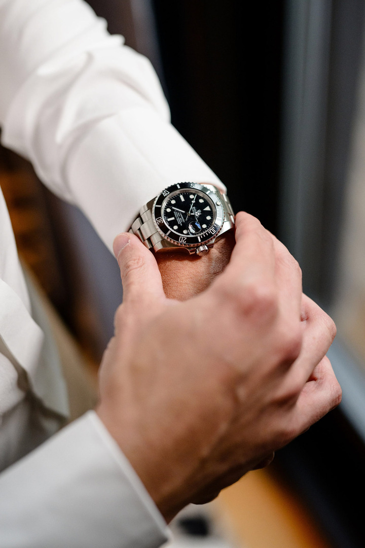 Groom adjusting his watch, close-up shot.
