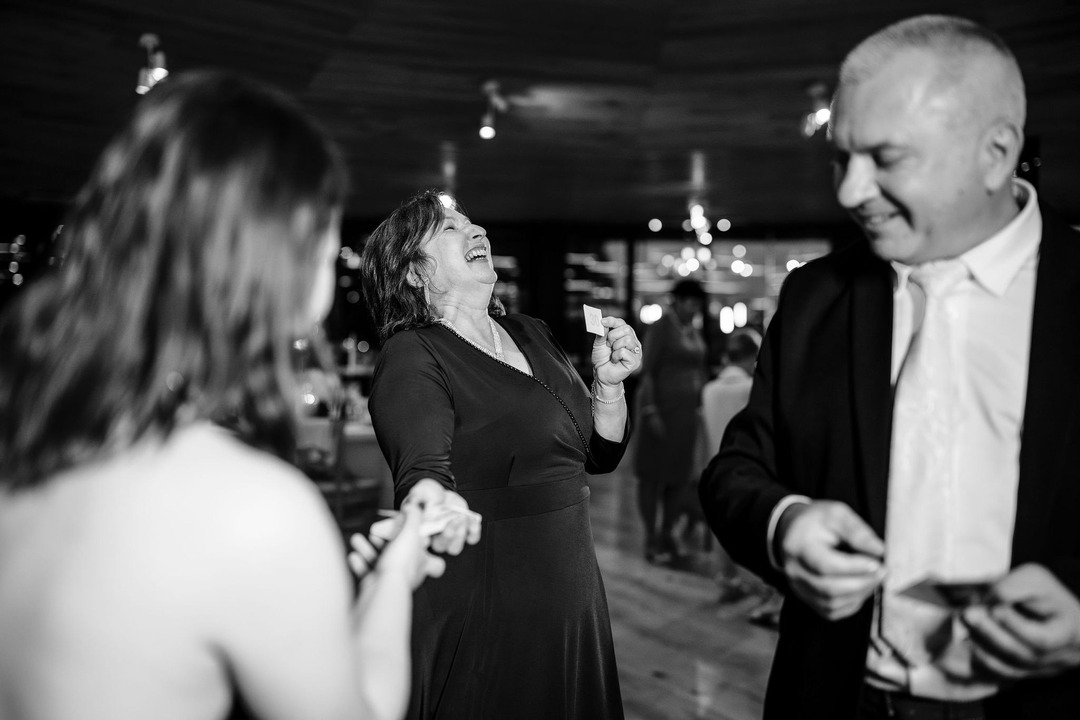 Wedding guests playing a party game, laughing wholeheartedly at the situation.
