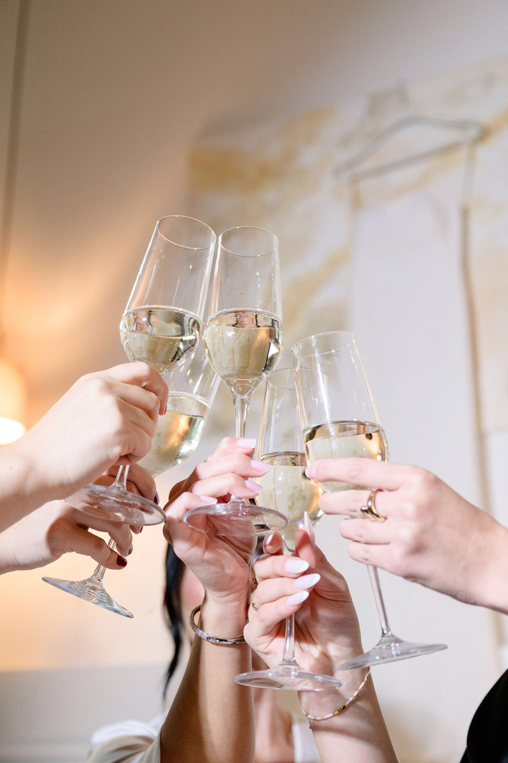 Close-up of raised champagne glasses clinking together in a toast.
