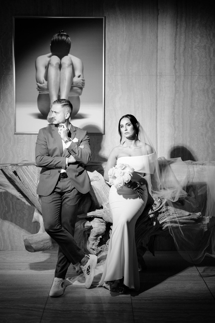 Black-and-white photo of the newlyweds casually sitting, leaning against a decoration in the SPA area of Villa Cattaleya.
