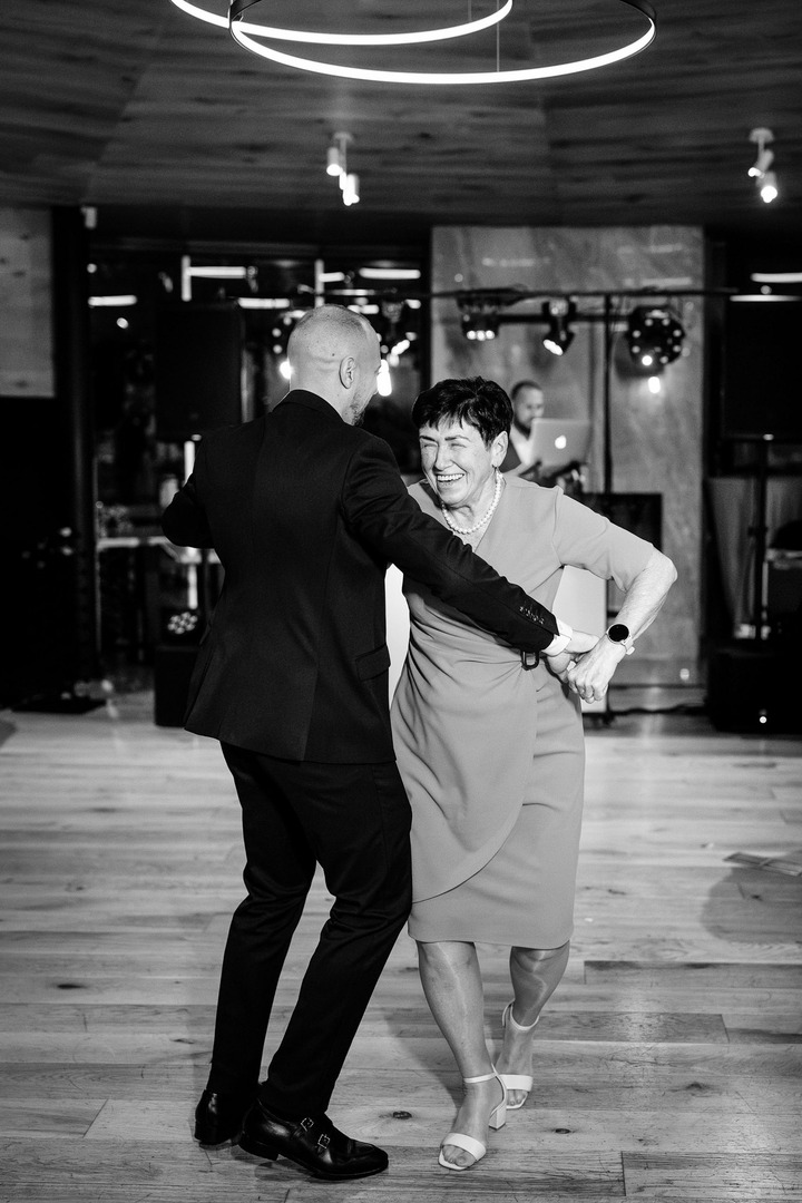 Black and white photo of a couple dancing together on the dance floor.
