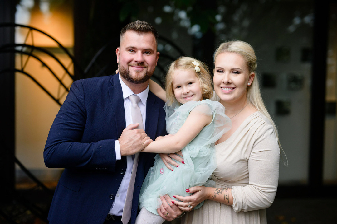 Family with a little girl smiling and posing for the camera.
