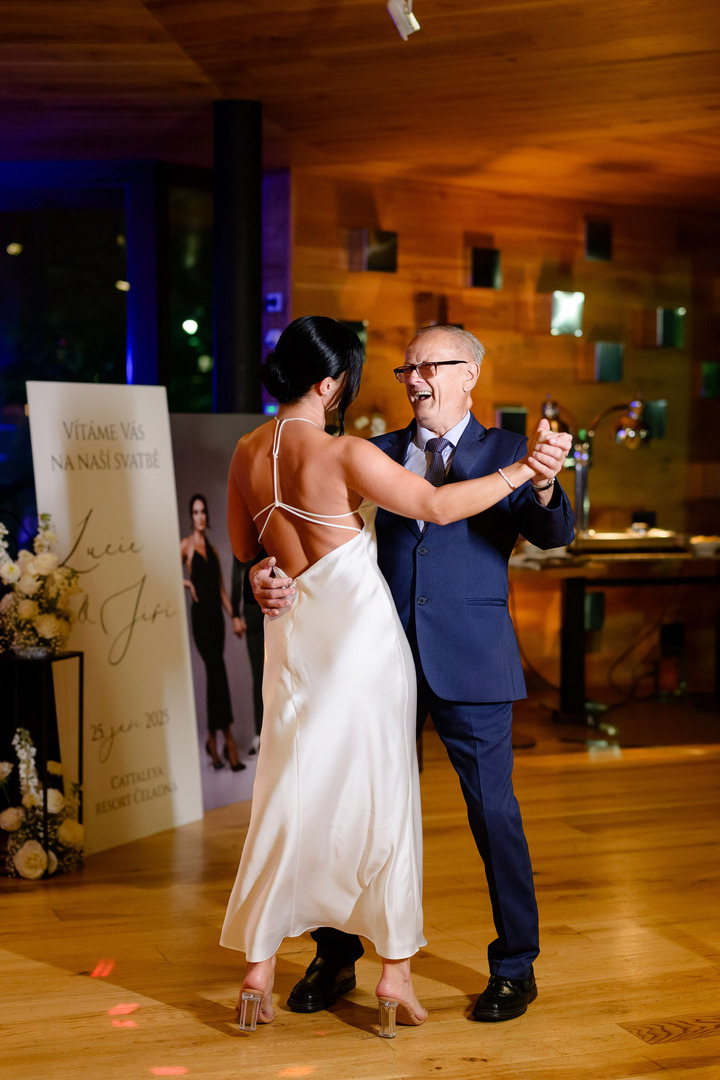 The bride dances with her grandfather, both smiling.
