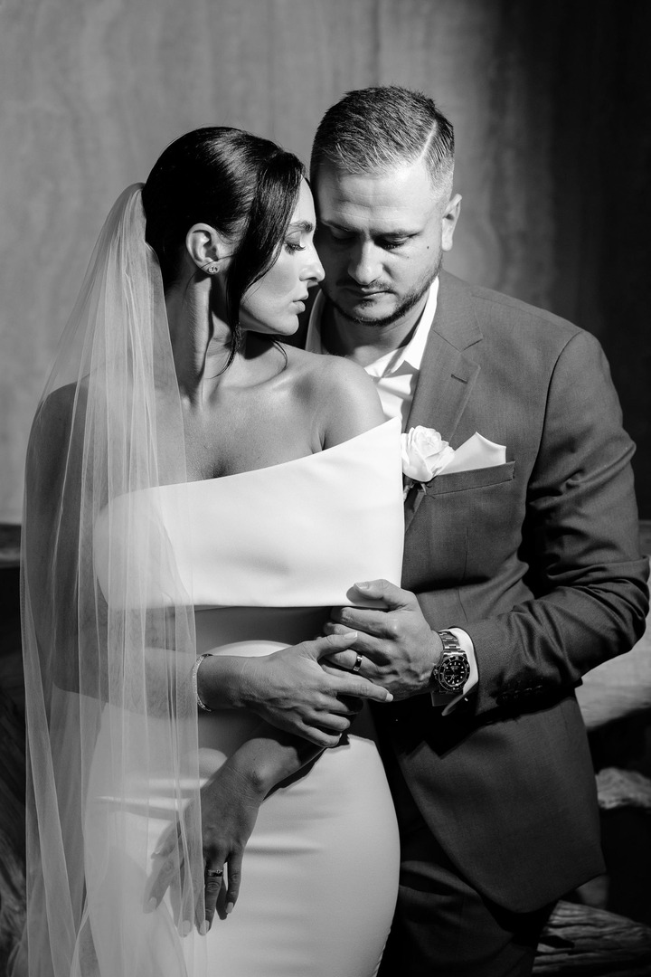 The groom and bride in close proximity, sharing an intimate embrace.
